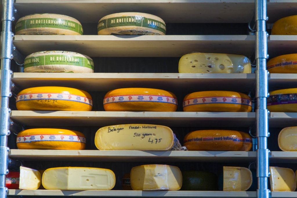 des fromages entiers de Hollande sur des étagères