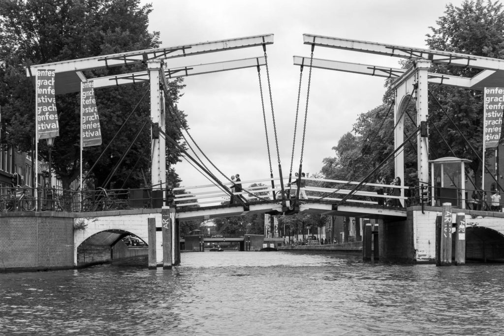 des gens marchent sur un pont au-dessus d'un canal